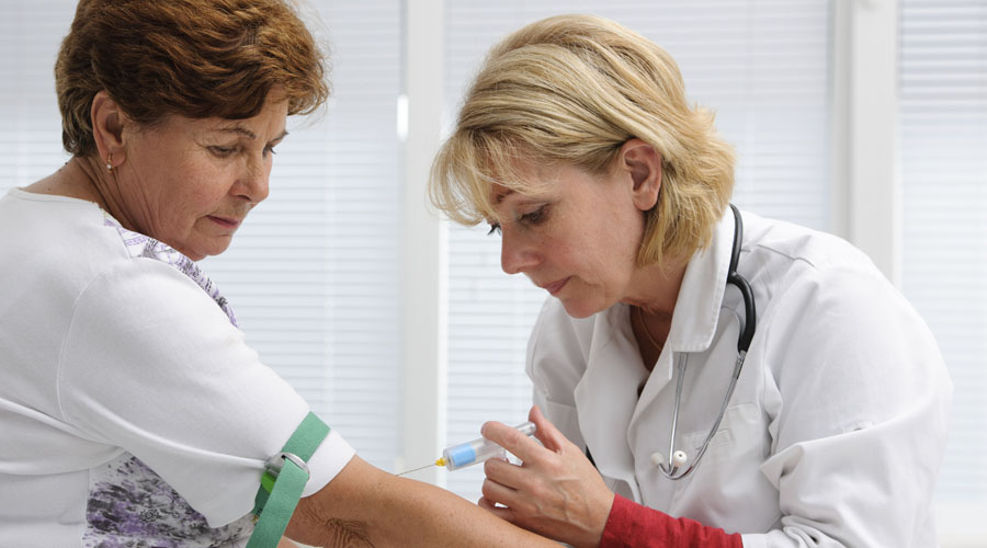 doctor with syringe is taking blood for test