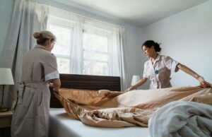 women putting bed sheet in a bed
